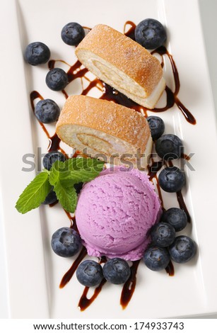 Slices of sweet cream roll with blueberry ice cream and fresh fruits