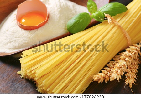 Bakery ingredient, pasta, flour, egg and tomato on a cutting board