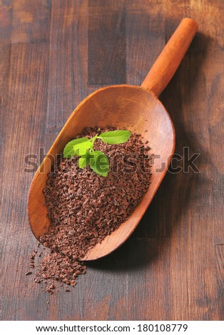 Chocolate powder in a wooden scoop isolated on white