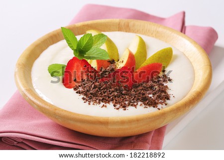 Swemolina pudding  ornated with fresh fruit and chocolate curls in a bowl