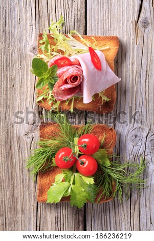 Two pieces of toast with ham and vegetables