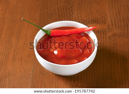 Bowl of spicy salsa dip with red chili pepper