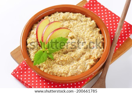 Bowl of oats porridge with fresh apple