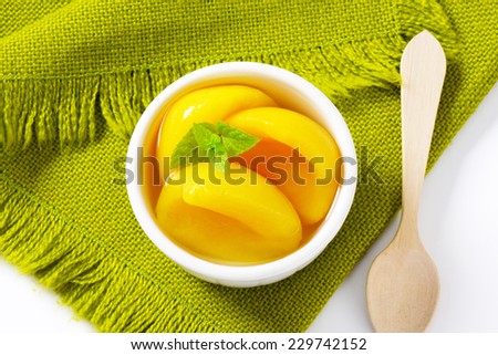 Canned yellow peach in porcelain bowl