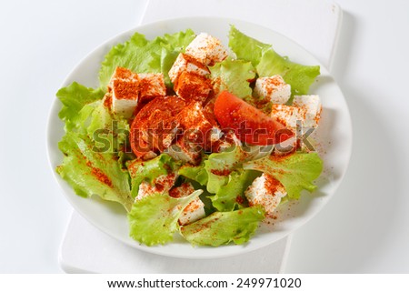 Bowl of vegetable salad with cubes of feta cheese