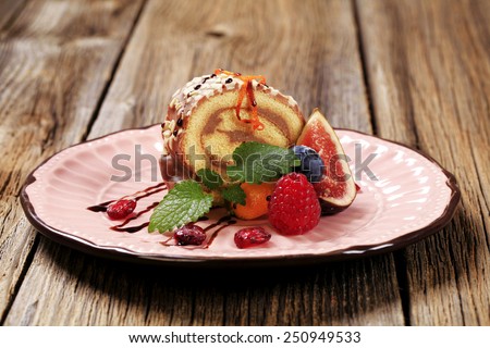 Chocolate Swiss roll garnished with fresh fruit