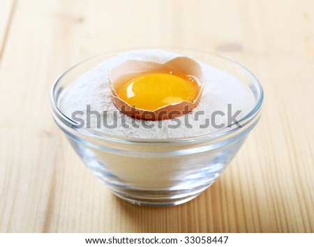 Cracked egg in a bowl of flour