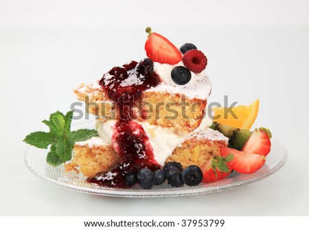 Slices of sponge cake with cream cheese and fruit