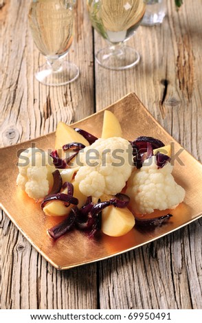 Cauliflower and potatoes garnished with Spanish onion
