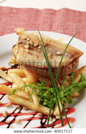 Pan fried fish fillet with baked potato and French fries