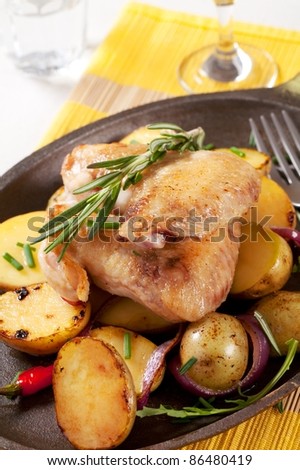 Roasted chicken wings and potatoes on a skillet