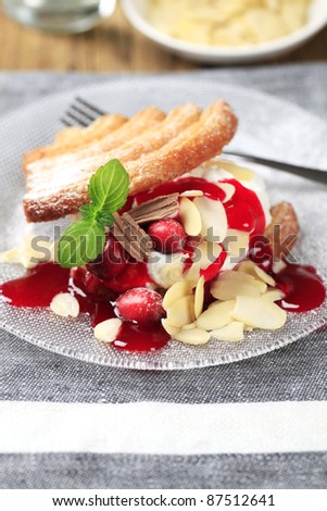 Fan-shaped puff pastries with cream, cranberries and syrup