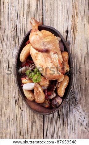 Cooked chicken served with baked potatoes and vegetables