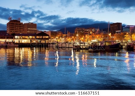 Hobart waterfront photographed at night with city skyline and fishing boats