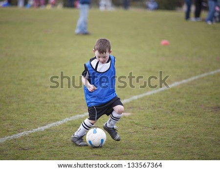 Six year old boy playing Soccer on a Saturday morning