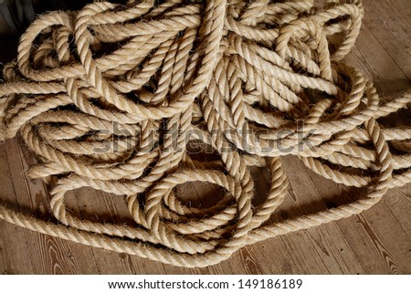 Pile of strong rope lying on timber floorboards