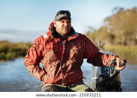 Eel Fisherman in Aluminium dinghy travelling to collect Eels from nets, Lake Crescent, Tasmania