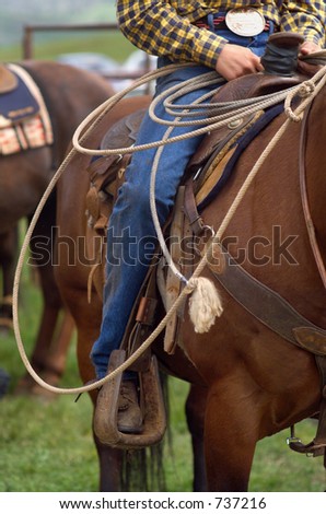 Detail close up of Western Horse Saddle and Lasso rope, and Rodeo Cowboy in the saddle