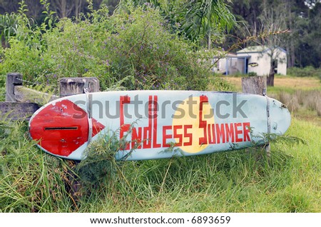 Old surfboard used as a sign on a rural property, Endless Summer