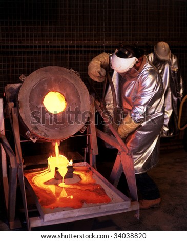 Gold mine worker pours molten Gold into ingot mold