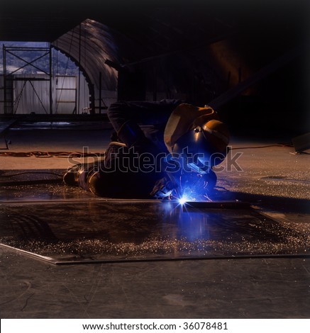 Ship building worker welding sheets of Aluminum at boat building yard