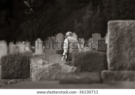 View of various sandstone and marble headstones with an old man walking in an old graveyard