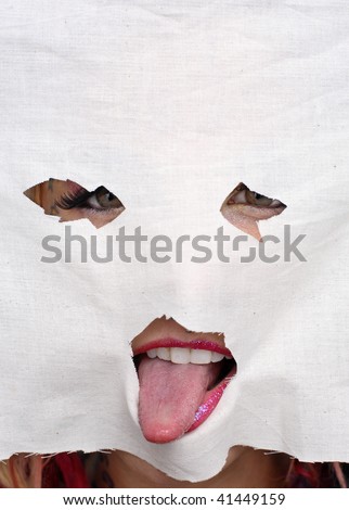 Young woman holding a face mask cut out  of material mask in front of her face