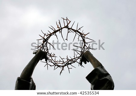Detail close up of a sculpture holding the Crown of Thorns over their head