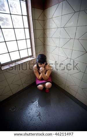 Girl in a Pink Dress alone in a shower room, crouched in the corner