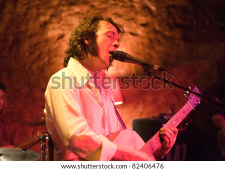 Musician singing and playing guitar in a live performance