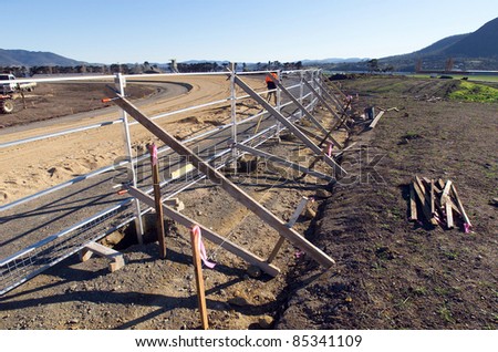 View of new fence being constructed around a new horse racing track