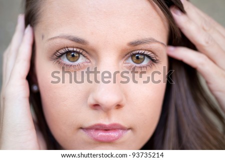 Close up of beautiful female face with hands close to her face