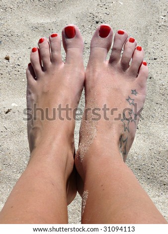 stock photo Young woman's feet covered in sand