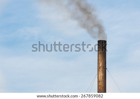 Factory plant with balck smoke and blue sky