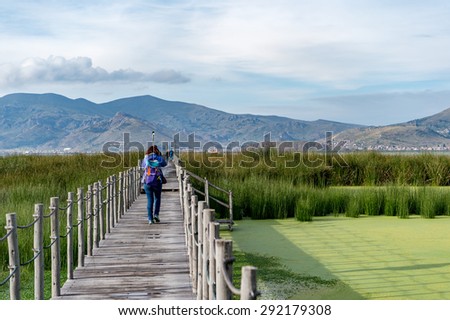 A girl walking to the pier, Lake titicaca, Puno, Peru