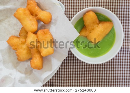 Fried dough stick with pandan coconut custard dip, Close up image