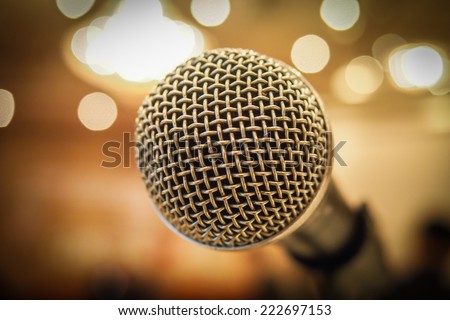 Close up of microphone in concert hall or conference room with lights in background. Macro with extremely shallow dof.
