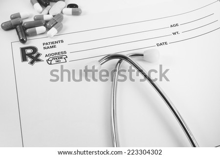 Medical concept Doctors Stethoscope and blank prescription form  With  pills ,  space for your message  : Black and white style.