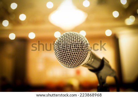 Microphone in concert hall or conference room with defocused bokeh lights  in background. Extremely shallow dof.