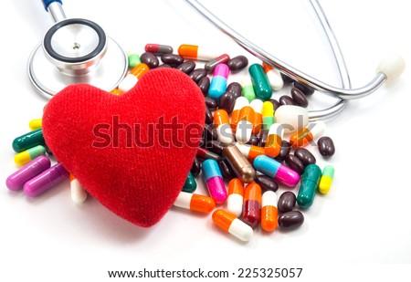 Medical concept : One red heart on Colorful  Pills  and doctors Stethoscope With white background for Cardiovascular disease or heart disease