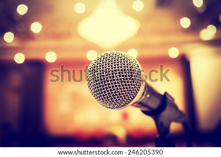 Microphone in concert hall or conference room with defocused bokeh lights  in background. Extremely shallow dof. : Vintage style
