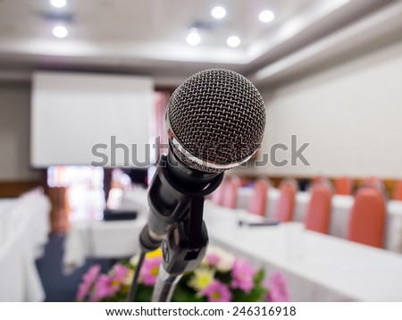 Close up of microphone in  conference room with de-focused bokeh lights in background. Extremely shallow dof.