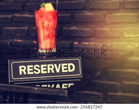 Vintage styled image of a reserved sign on a table in restaurant.