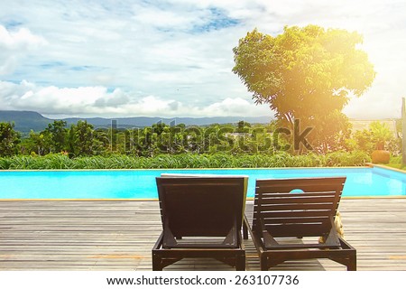 Pool beds on wooden ground  beside the public pool with light and mountain  in vintage style.