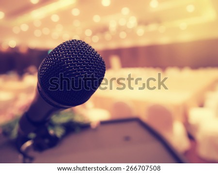 Black microphone in concert hall or conference room with defocused bokeh lights in background. Extremely shallow dof.  : Vintage style and  filtered process.