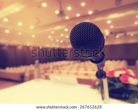 Black microphone in concert hall or conference room with defocused bokeh lights in background. Extremely shallow dof.  : Vintage style and  filtered process