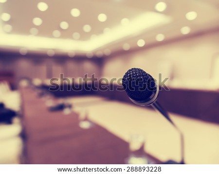 Microphone in concert hall or conference room with de focused bokeh lights in background. Extremely shallow dof. : Vintage style and filtered process