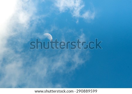 A  half moon in noon and beautiful blue sky and white clouds in good weather and summer day. Photo for background.