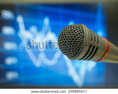 Microphone in  hall or conference room with defocused  financial trends  background. Concept for Business Conference.