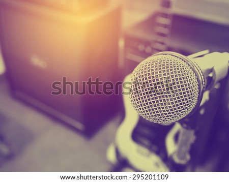 Black and white photo and lighting of The microphone in a recording studio or concert hall with amplifier in out of focus background. : Vintage style and filtered process.